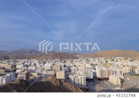 中東オマーン首都マスカットの街並みと山岳の写真素材