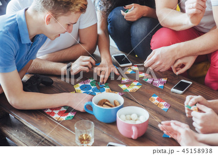 Top view creative photo of friends sitting at wooden table.  having fun while playing board game 45158938