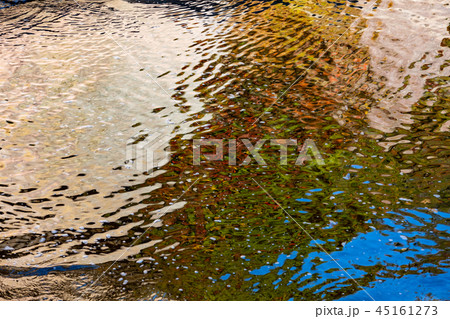 水面 渓谷の川面の波に映る紅葉と岩壁と青空 45161273