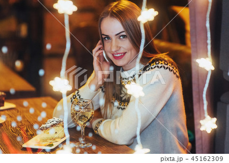Young beautiful woman sitting in cafe, drinking wine. Christmas, new year, Valentines day, winter Young beautiful woman sitting in cafe, drinking wine. Christmas, new year, Valentines day, winter 45162309