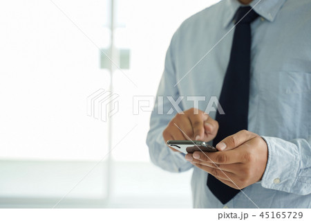 Business man hold the smartphone on the street Business man hold the smartphone on the street 45165729