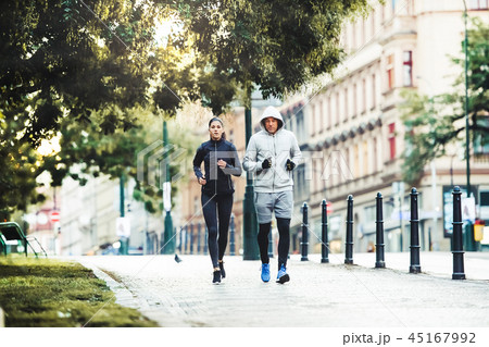 A fit couple running outdoors on the streets of Prague city. 45167992