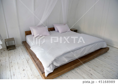 Interior of wooden cottage with large bed 45168989