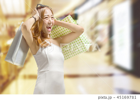 Chinese woman in white dress carrying shopping bag Chinese woman in white dress carrying shopping bag 45169781
