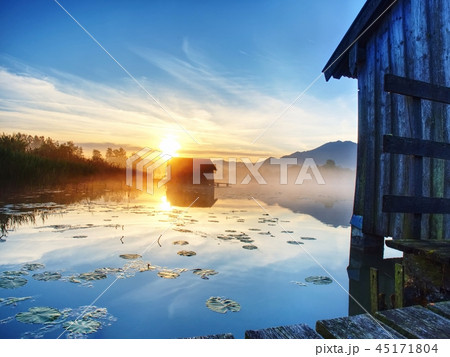 Morning at lake with traditional wooden boat house Morning at lake with traditional wooden boat house 45171804