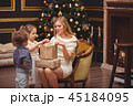 Mom and her children near the Christmas tree 45184095