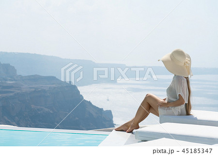 young woman enjoying a magnificent view of Santorini near the pool. young woman enjoying a magnificent view of Santorini near the pool. 45185347