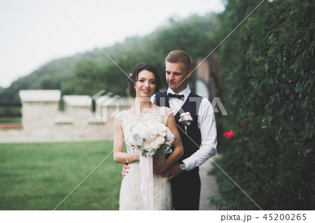 Happy wedding couple walking in a botanical park 45200265