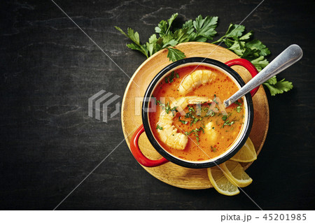 traditional Thai soup with shrimp in a red pot and a spoon with parsley traditional Thai soup with shrimp in a red pot and a spoon with parsley 45201985