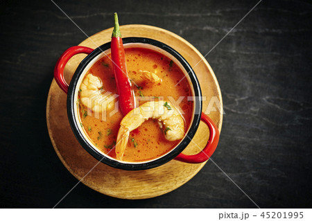 traditional Thai soup with shrimp in a red pot with chilli pepper traditional Thai soup with shrimp in a red pot with chilli pepper 45201995