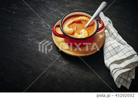 traditional Thai soup with shrimp in a red pot and a spoon 45202032