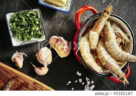fresh delicious raw tiger prawns in a pot with parsley, lemon, butter and garlic fresh delicious raw tiger prawns in a pot with parsley, lemon, butter and garlic 45202187