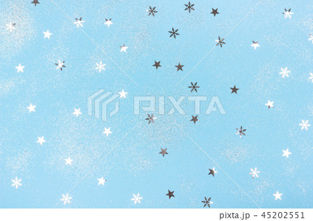 Metallic silver confetti on light blue background. 45202551