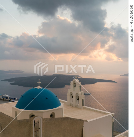 sunset over aegean sea with view to Virgin Mary Catholic Church Three Bells of Fira, Santorini. 45206060