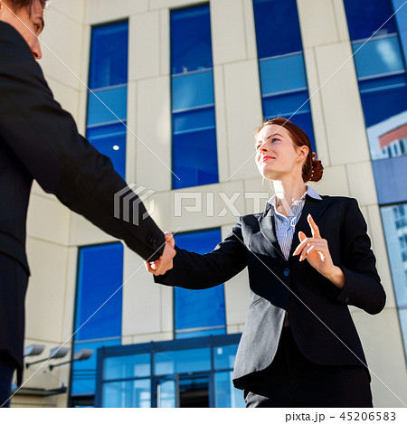 Business woman and man shaking hands outdoors. Business cooperation concept 45206583