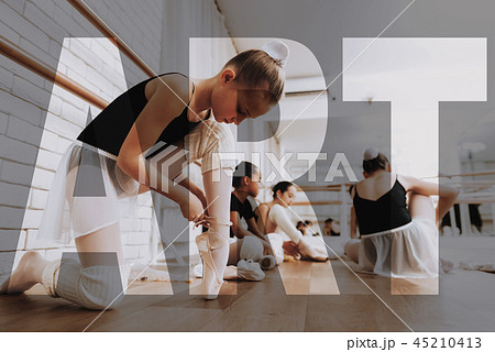 Young Ballerinas Tie Pointe Shoes at Dance Room. 45210413