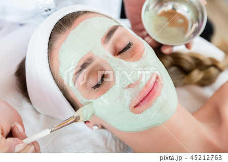 Woman getting facial care by beautician at spa salon Woman getting facial care by beautician at spa salon 45212763