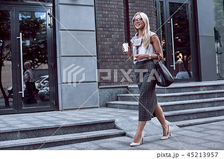 Young stylish woman walking on street of downtown with smile 45213957