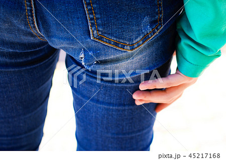 Hole in jeans in the buttocks area of the buttocks 45217168