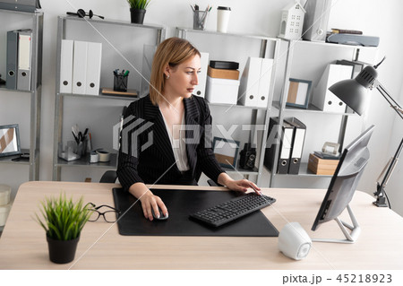 A young girl working at a computer in the office. 45218923