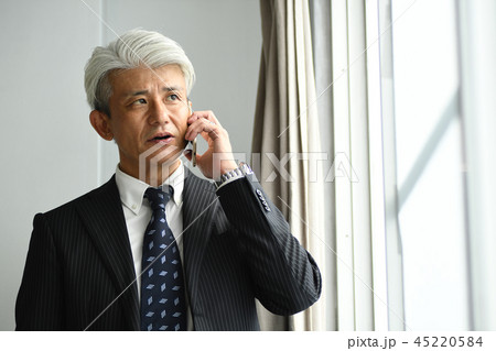 窓辺で電話をする中年ビジネスマン　ロマンスグレー 45220584