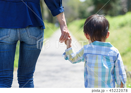 手をつないで歩く親子 後ろ姿 母親と子どもの写真素材