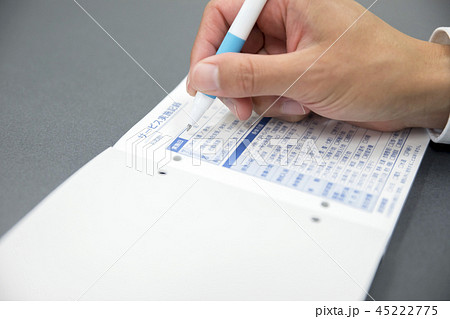 介護イメージ　サービス実施記録をつける介護福祉士男性手元 45222775