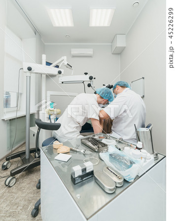 Doctor used microscope. Dentist is treating patient in modern dental office. Operation is carried Doctor used microscope. Dentist is treating patient in modern dental office. Operation is carried 45226299
