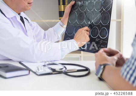 doctor analyzing a scan or x-ray film or explains a CT scan thou 45226588