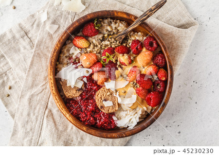 Trendy vegan bowl of oatmeal porridge with berries Trendy vegan bowl of oatmeal porridge with berries 45230230
