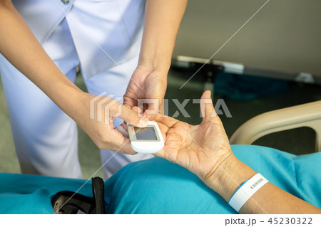 Nurse checking blood sugar level patoent with glucometer in hospital. 45230322