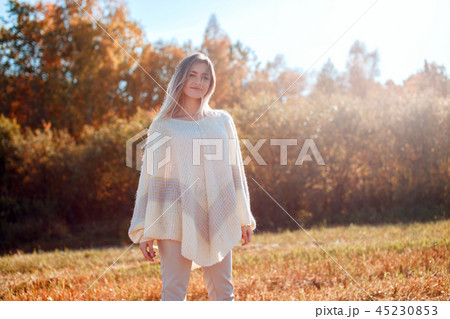 Pretty girl posing on camera and enjoying sunny autumn day. Pretty girl posing on camera and enjoying sunny autumn day. 45230853