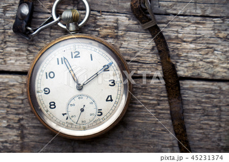 Vintage swiss pocket watch with a leather strap on the wooden boards 45231374