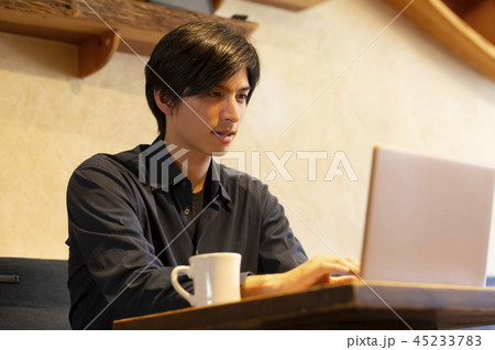 カフェで仕事をするカジュアル男性 45233783