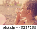 Five year old beautiful little girl blows soap  45237268