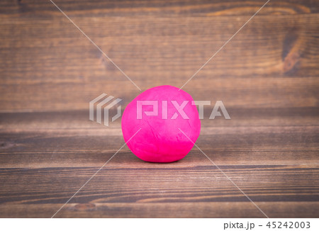 Red plasticine ball on wood Red plasticine ball on wood 45242003