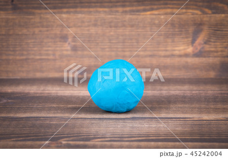 Blue plasticine ball on wooden Blue plasticine ball on wooden 45242004