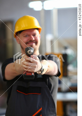 Arms of worker using electric drill closeup Arms of worker using electric drill closeup 45243810