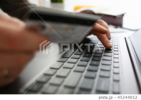 Male arms hold credit card press buttons making transfer Male arms hold credit card press buttons making transfer 45244012