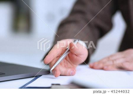 Male arm in suit and tie hold silver pen 45244032