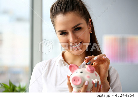 Happy beautiful woman put silver quarter in slot portrait 45244854