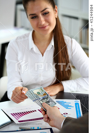 Male arm pay bunch of hundred dollars bills 45244984