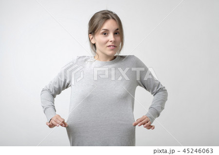 Losing weight concept. Caucasian thin woman showing that her dress is big for her. Losing weight concept. Caucasian thin woman showing that her dress is big for her. 45246063