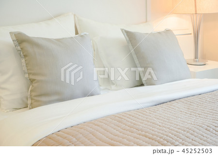 Light brown pillows on comfortable bed in bedroom Light brown pillows on comfortable bed in bedroom 45252503