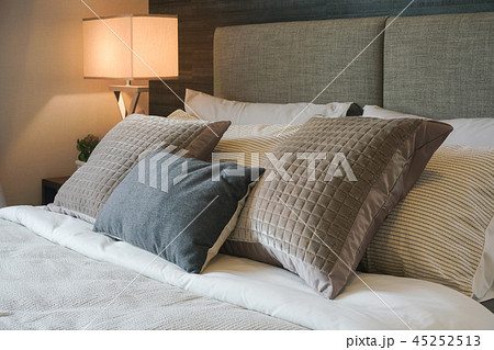 Gray and brown pillow on bed with reading lamp Gray and brown pillow on bed with reading lamp 45252513