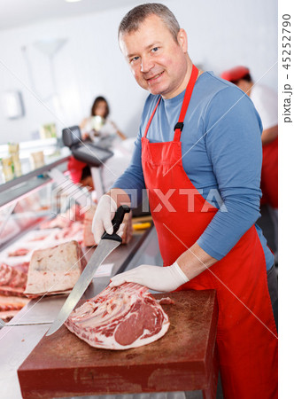 Smiling man seller cutting meat in shop 45252790