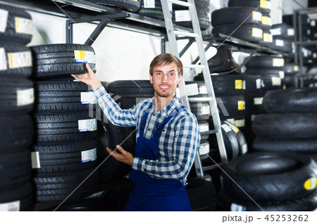 Man standing with auto tires Man standing with auto tires 45253262