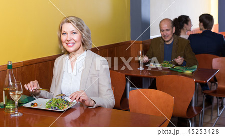 Mature female having lunch in restaurant . Mature female having lunch in restaurant . 45253428