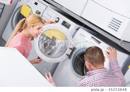 Positive family chooses new washing machine in shop Positive family chooses new washing machine in shop 45253648