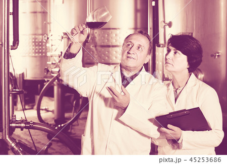 Expert and wine maker estimate quality of red wine in wineglass 45253686